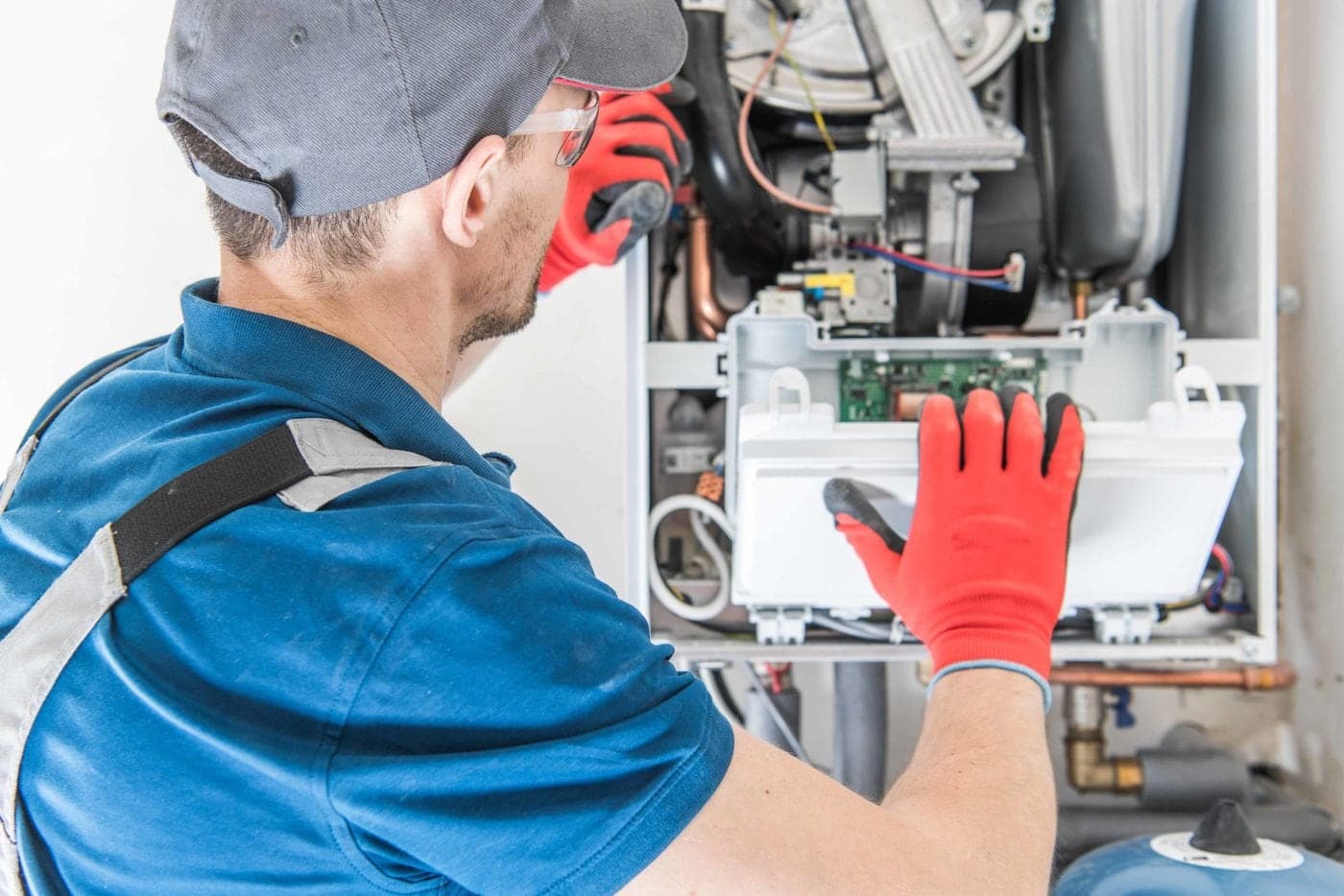 tech-working-on-furnace-indoor-unit-scaled